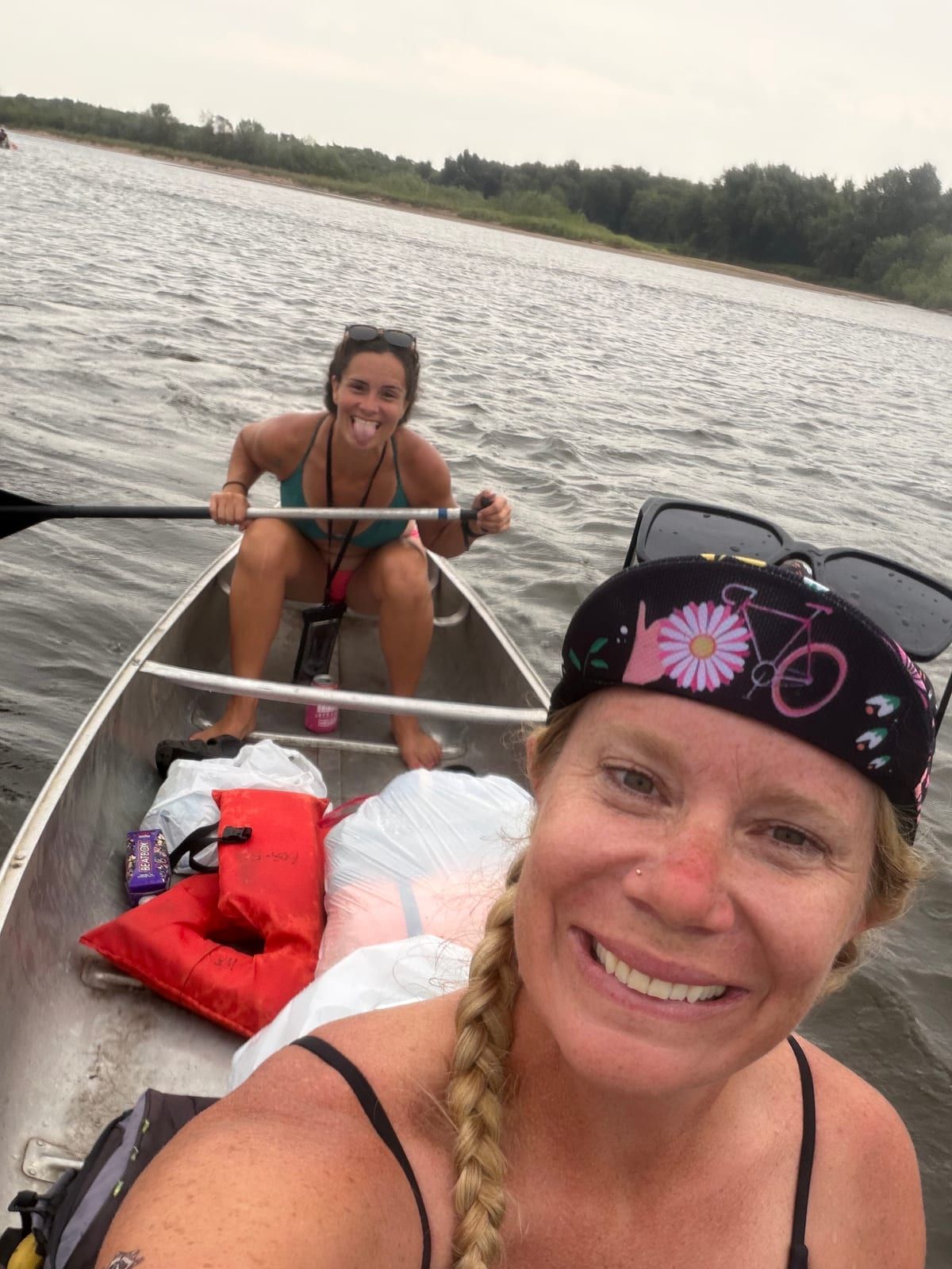 Two paddlers in a canoe loaded with dry bags, the one in front taking the photo