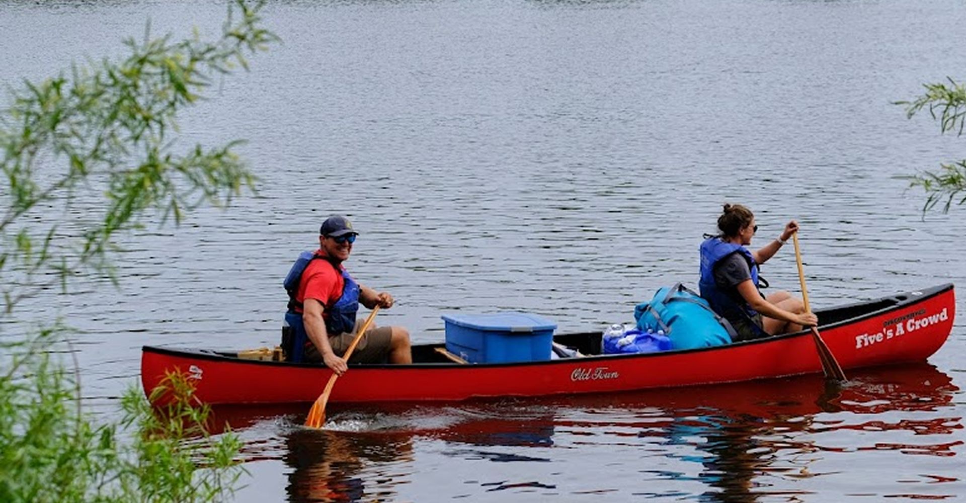Two paddlers in a red canoe loaded with dry bags on the Wisconsin River