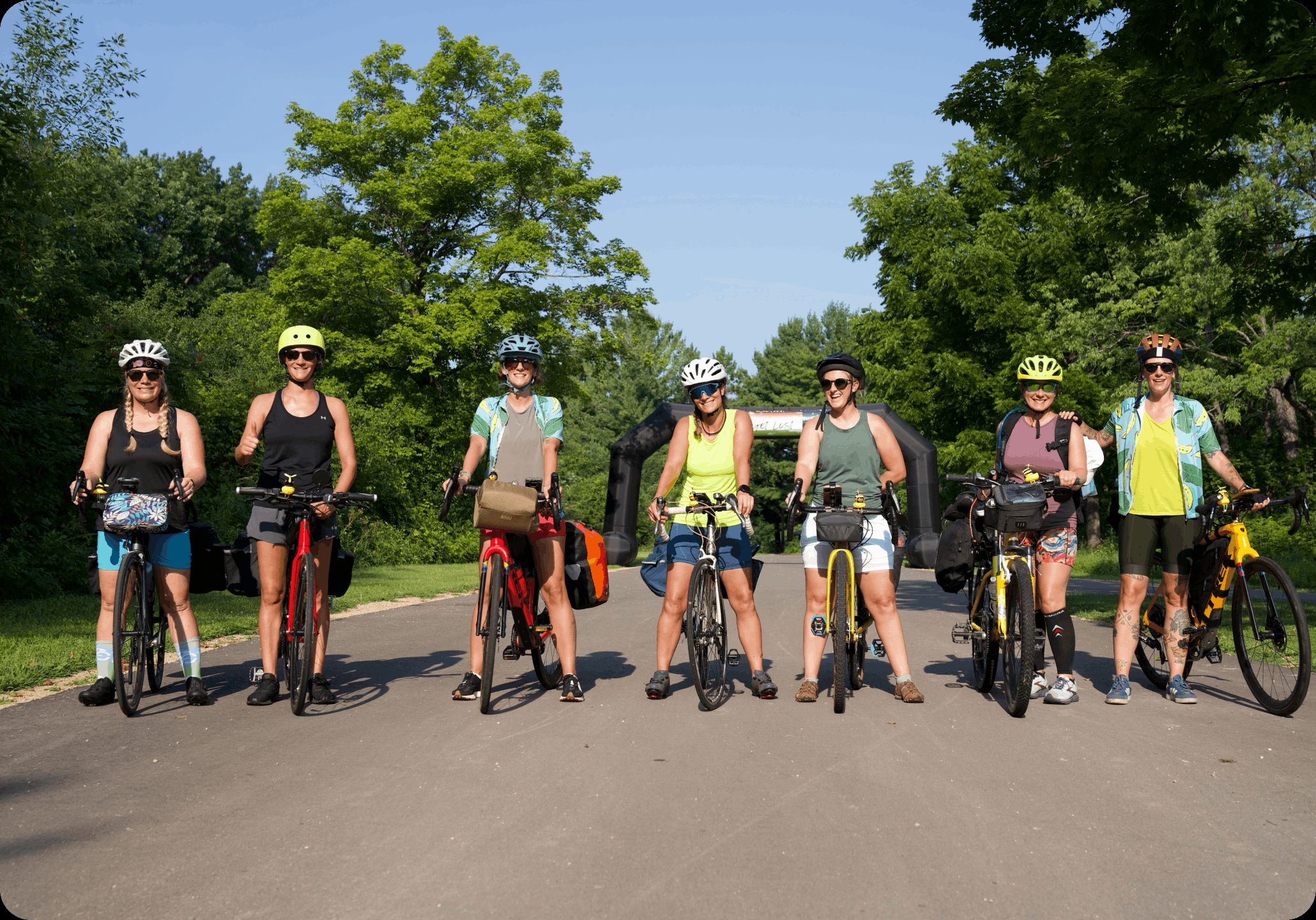 A line of riders on loaded bikes spread across a country road