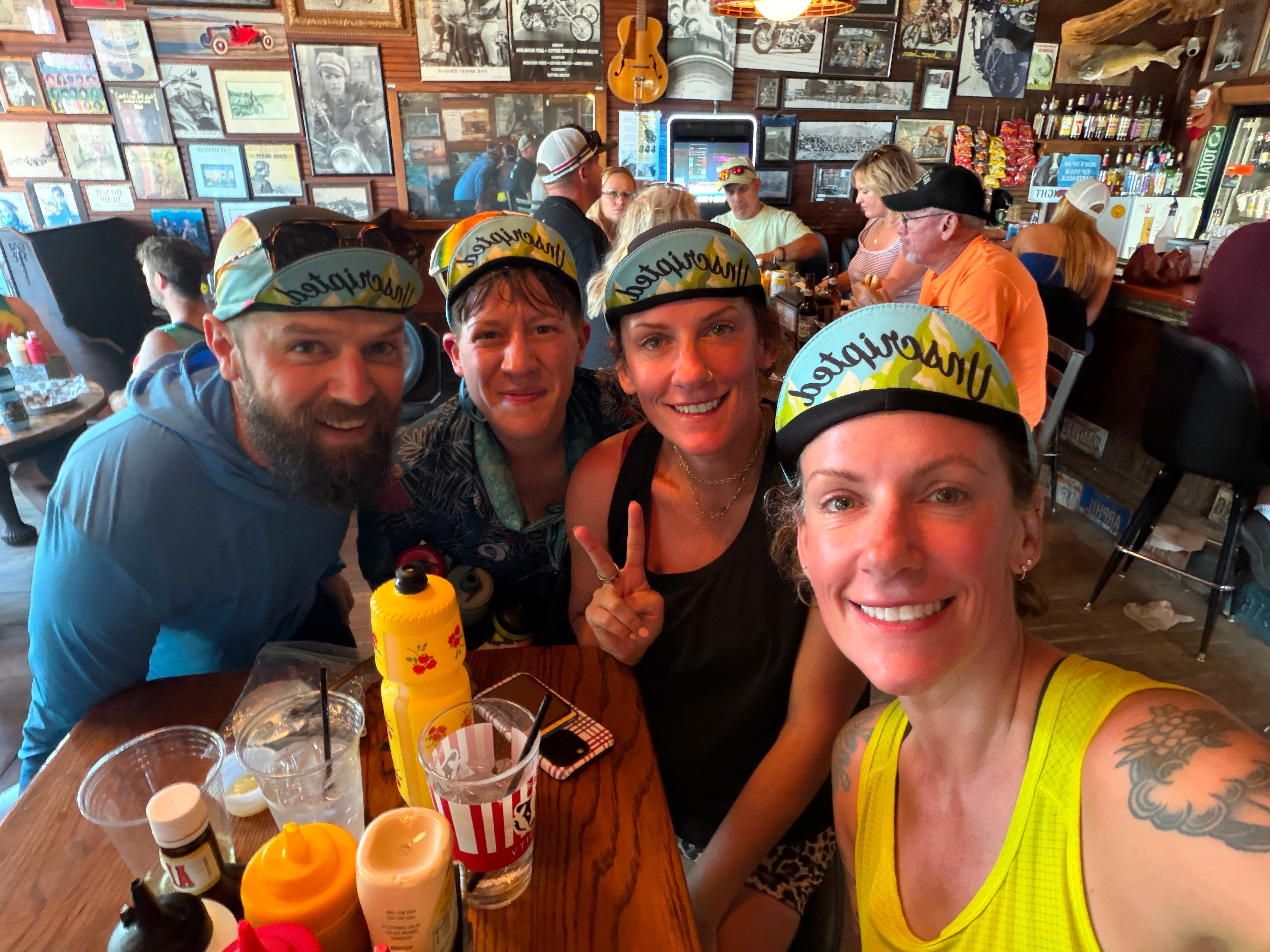 Riders crowded around a tavern table with drinks